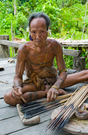MENTAWAI PEOPLE, WEST SUMATRA, SIBERUT ISLAND, INDONESIA - 16 NOVEMBER 2010: Men Mentawai tribe prepare arrows for hunting.のeditorial素材