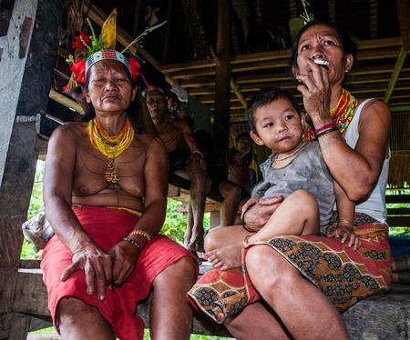 MENTAWAI PEOPLE, WEST SUMATRA, SIBERUT ISLAND, INDONESIA - 03 OKTOBER 2011: Mentawai tribe Family sitting in the doorway of his house.のeditorial素材