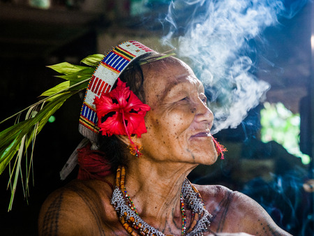 MENTAWAI PEOPLE, WEST SUMATRA, SIBERUT ISLAND, INDONESIA - 16 NOVEMBER 2010: Portrait of a man Mentawai tribe in traditional headdress.のeditorial素材