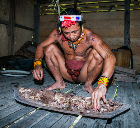 MENTAWAI PEOPLE, WEST SUMATRA, SIBERUT ISLAND, INDONESIA - 03 OKTOBER 2011: Man Mentawai tribe preparing food for the family.のeditorial素材
