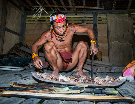 MENTAWAI PEOPLE, WEST SUMATRA, SIBERUT ISLAND, INDONESIA - 03 OKTOBER 2011: Man Mentawai tribe preparing food for the family.のeditorial素材