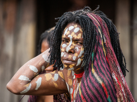 DANI VILLAGE, WAMENA, IRIAN JAYA, NEW GUINEA, INDONESIA - 15 MAY 2012: Portrait of Woman Dani tribe in ritual coloring on the body and face.のeditorial素材