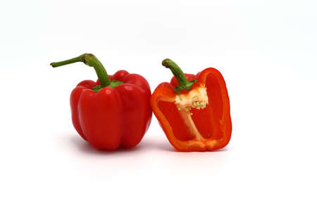 One red ripe sweet pepper and one half pepper on a light background. Natural product. Natural color. Close-up.の写真素材