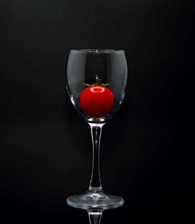 Red ripe tomato in a glass goblet. Natural product. Natural color. Close-up.の写真素材