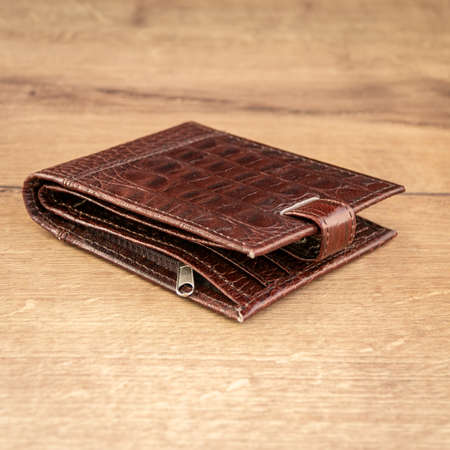 Brown leather wallet on a wooden background. close-up.の写真素材