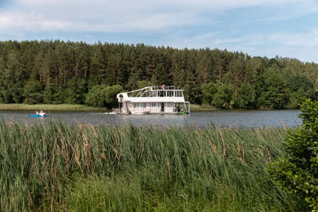 Minsk. Belarus. 08.22.2022. A ship in the form of a two-story houseboat floats along the river. summer outdoor recreation. river excursion.の写真素材