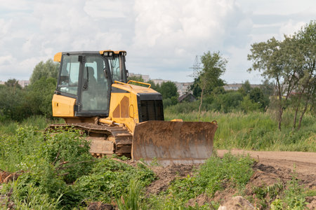 Crawler bulldozer clears the ground with a metal shield. Landscaping. road construction works. The caterpillar bulldozer is used for layer-by-layer movement of soils.の写真素材
