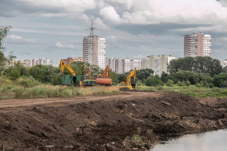 Crawler excavators dig the earth with a bucket. road construction works. Clearing the construction site. Peat mining. Drainage of swamps.の写真素材