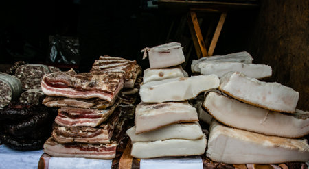 Large chunks of salted bacon on the counter in the village market. Natural product from an organic farm, produced using traditional methods. The fibrous texture of bacon and spices is clearly visible.の写真素材