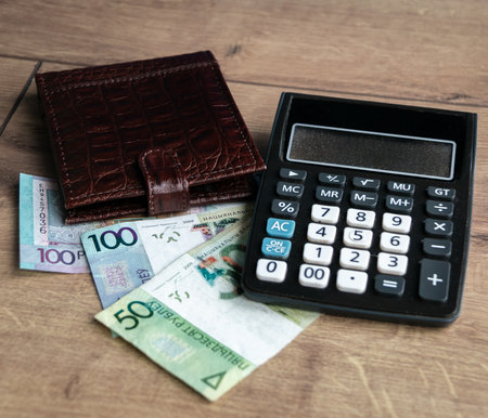 Belarusian money, wallet, calculator and bank card. The concept of paying bills and increasing prices. The concept of storing cash on a bank card. payment concept. close-up.の写真素材