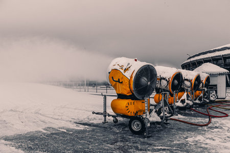 Snow cannons spray artificial snow crystals. snow guns. Production of artificial snow. Cars make...