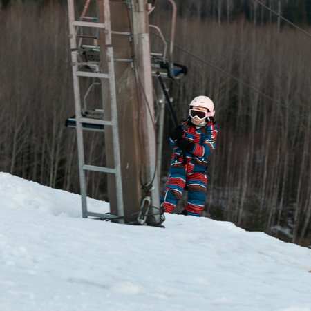 logoisk. Belarus. 05/01/2023. A teenage snowboarder in special equipment climbs uphill on a drag lift. Winter extreme sport. Ski resort in Belarus. winter holidays.のeditorial素材