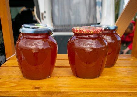 Honey in glass jars. Sale of honey in transparent glass jars at the agricultural market. Sale of...