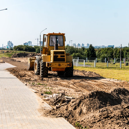 A wheeled bulldozer clears the ground with a metal shield. road construction works.の写真素材