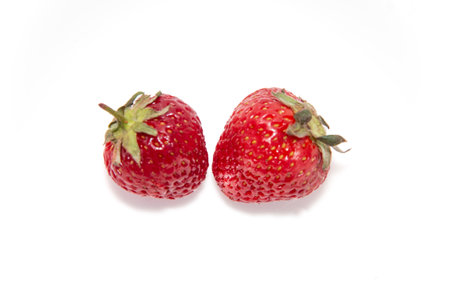 Two fresh ripe strawberries on a white background. Beautiful and tasty strawberries. Dessert. close-upの写真素材