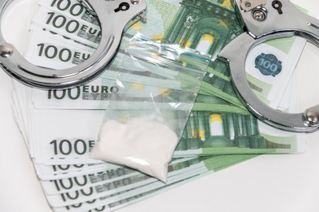 Euro banknotes and a bag of white powder on a white background. The concept of punishment for the sale of drugs. close-up.の写真素材