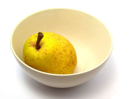 A pear in a bowl isolated whiteの写真素材