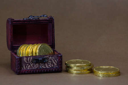 Chest with Chocolate coins on dark brown backgroundの写真素材