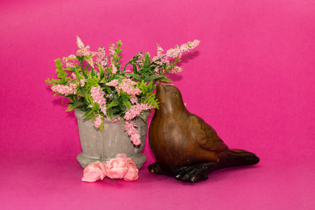 Wooden bird with pink flowers on pink backgroundの写真素材