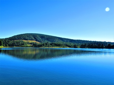 hill landscape reflected in a mountain lakeの写真素材