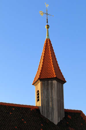 Roof and tower A small tower with a weathercock on the roof of a houseの写真素材