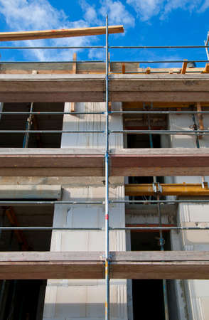 Construction site detail of a house stonework with scaffoldの写真素材