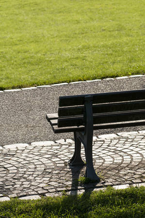 Brown bench in a public park in sunshineの写真素材