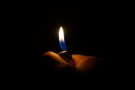Hand holding lighter in dark background