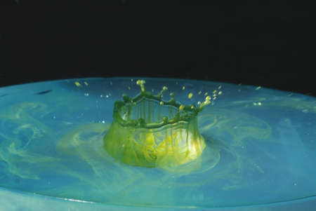 Drops of green-blue background  make a crown-shaped rippleの写真素材