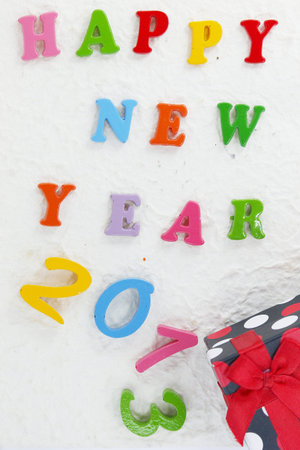 Colorful character made   from resin  Happy New Year put word on Mulberry paper and red Gift 