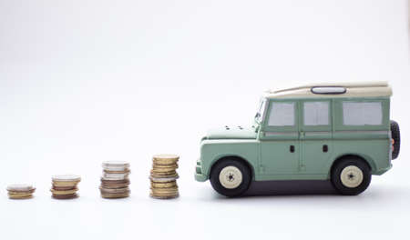 Stacked coins with Green car model on business saving and investment conceptの写真素材