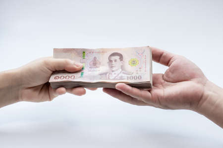 Closeup hand of a woman holding Thai-money sent to hand of a man, viruses and bacteria. Concept. Covid-19 or Coronavirus, isolated white backgroundの写真素材