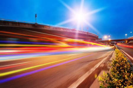 High speed traffic and blurred light trails under the overpass at night sceneの写真素材