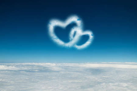 Two heart shaped clouds in the blue skyの写真素材