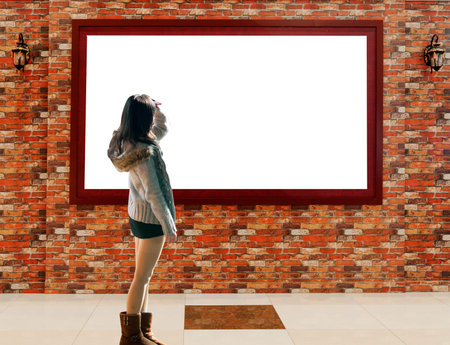 A girl looks at the ad on the wallの写真素材