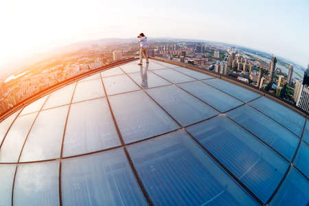 The keen photographer on a roof of the house の写真素材