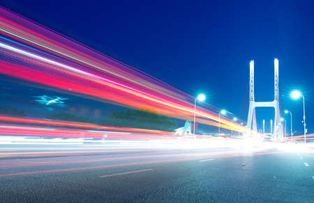 cars light trails on the modern bridge at duskの写真素材