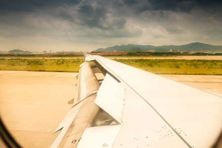 the wing is moving up when airplane is landing to runwayの写真素材