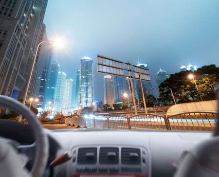 Driver's hands on a steering wheel of a car and night sceneの写真素材
