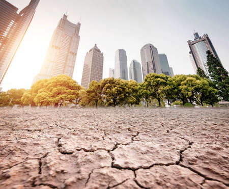 A city looks over a cracked earth landscapeの写真素材
