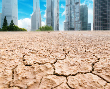 A city looks over a cracked earth landscapeの写真素材