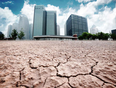 A city looks over a cracked earth landscapeの写真素材