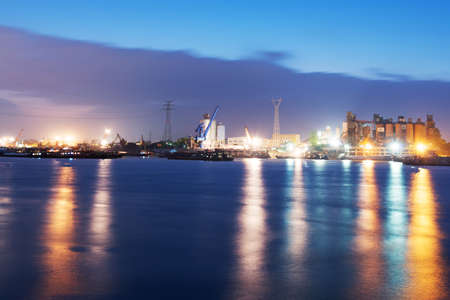 Container ship in the harbor, night shot. Cloudy sky.の写真素材