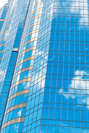 Clouds reflected in windows of modern office building