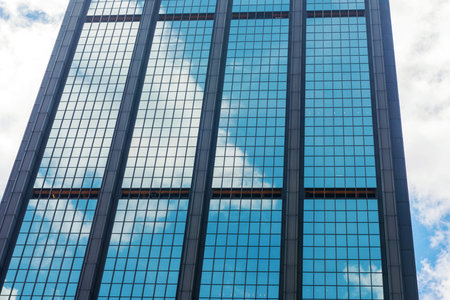 Clouds reflected in windows of modern office building