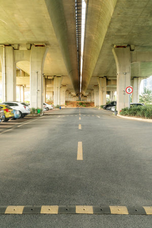 Concrete structure and asphalt road space under the overpass in the cityの写真素材