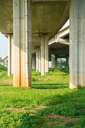 Concrete structure and asphalt road space under the overpass in the cityの写真素材