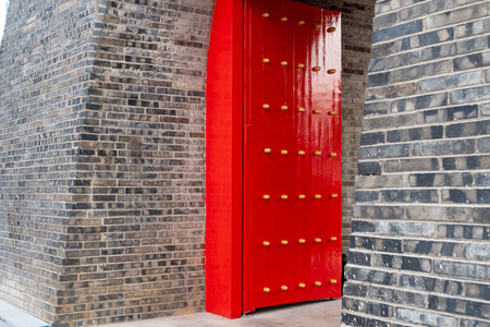 Antique traditional Chinese door style handle knocker with brass handles symbolic of lion head on red wood Doorの写真素材
