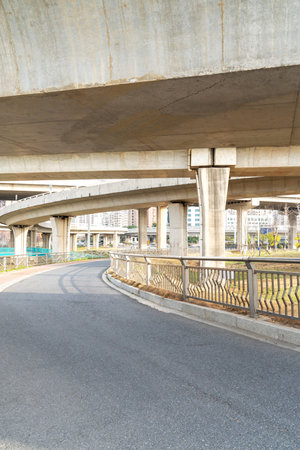 Concrete structure and asphalt road space under the overpass in the cityの写真素材
