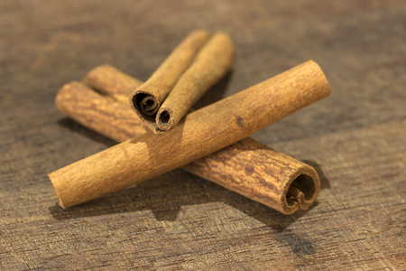 closeup detail of cinnamon sticks on wooden boardの写真素材